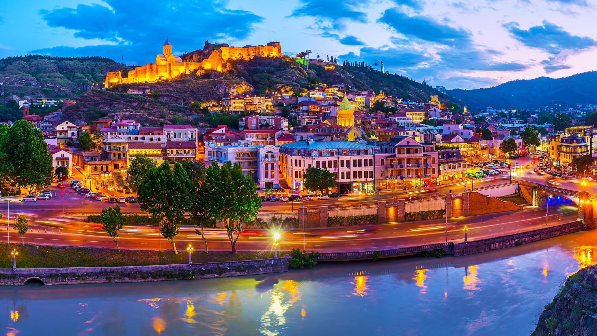Old Tbilisi hillside lit up at dusk